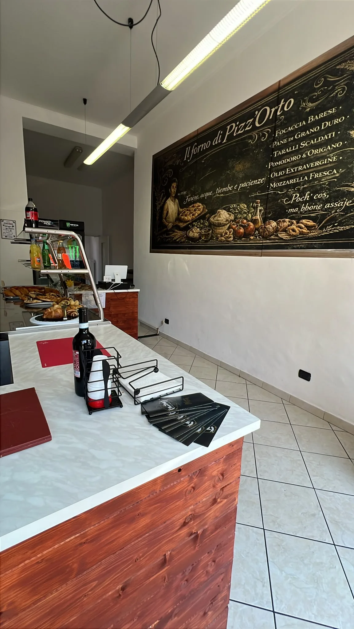La bottega del Punto Pizz’Orto a Cesate: bancone, vetrina e murale del forno